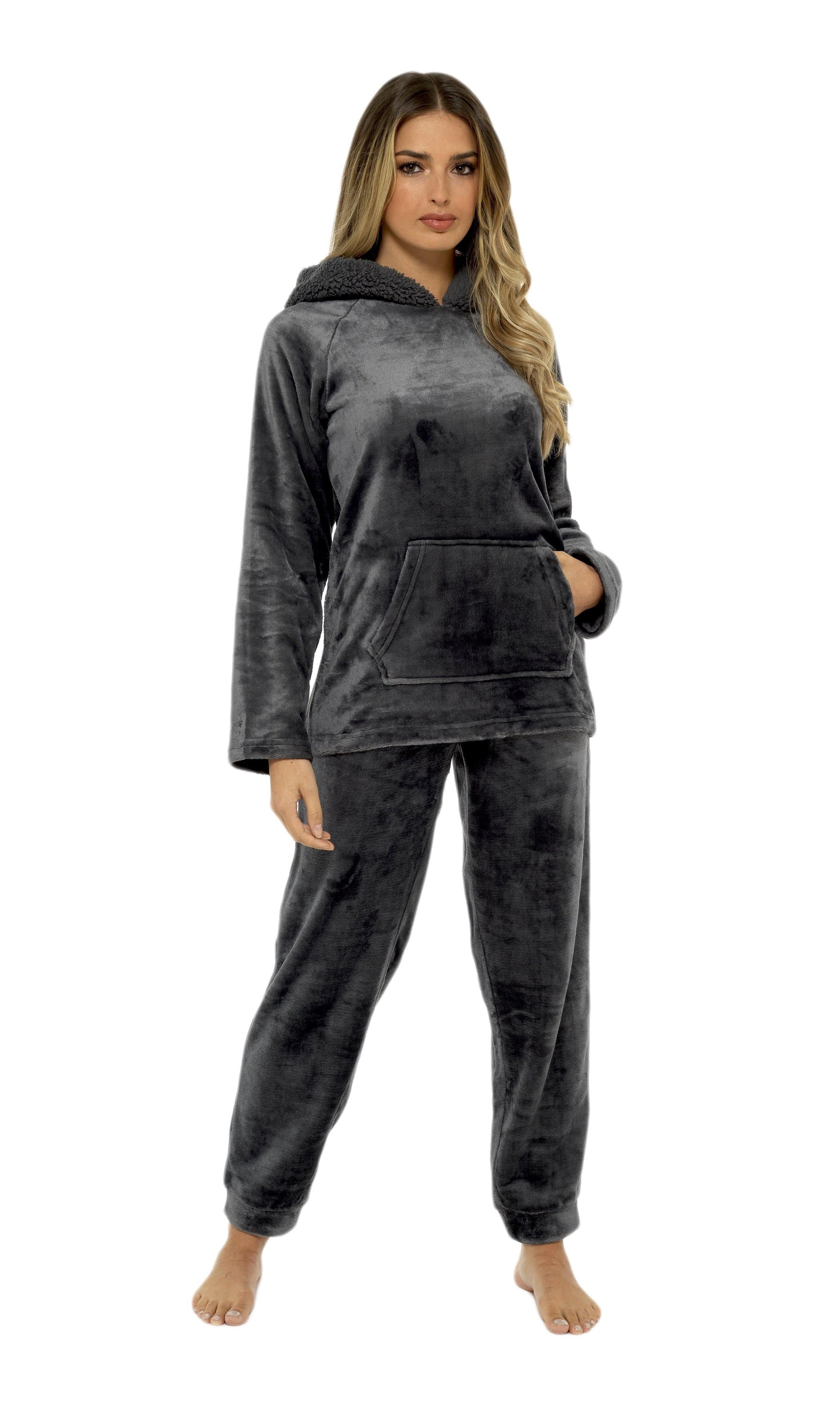 Woman wearing a dark gray hoodie and pants set on a white background
