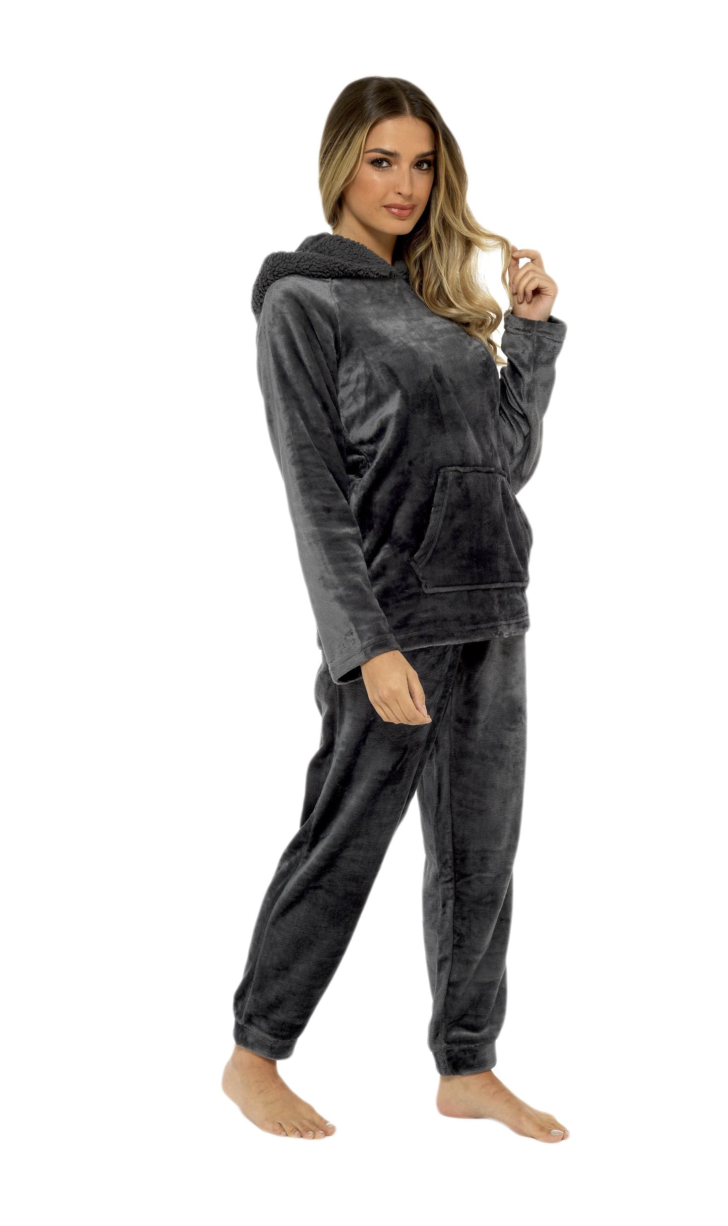 Woman wearing a dark gray hoodie and pants set on a white background