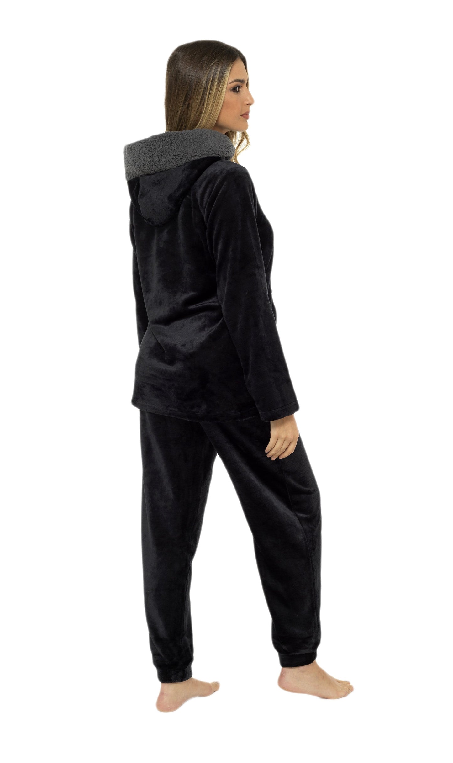 Person wearing a black fleece hoodie and pants on a white background